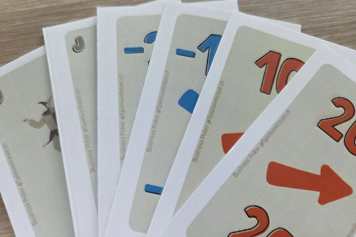 Business Poker Methode: Fächerartig ausgelegte Spielkarten mit Zahlen und Symbolen.