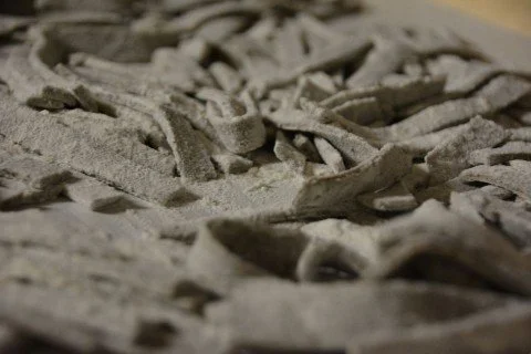 Nahaufnahme von handgemachtem, bemehltem Teig mit sichtbarer Struktur.