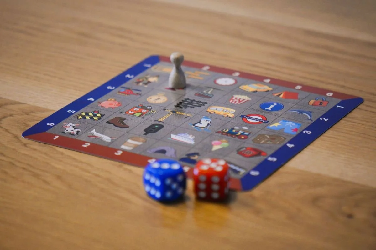 Spielmatte mit Holzfigur und zwei Würfeln auf Holztisch für Coaching und Workshops.