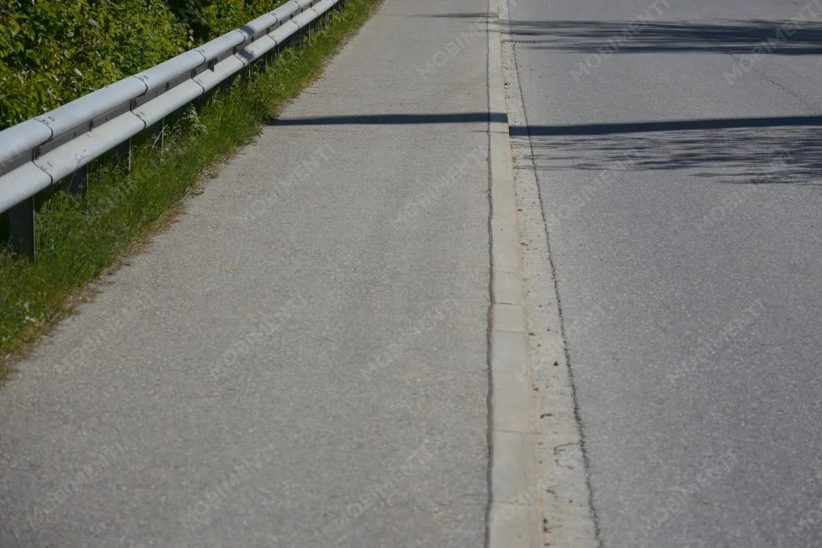 Gehweg und Strasse mit klarer baulicher Trennung