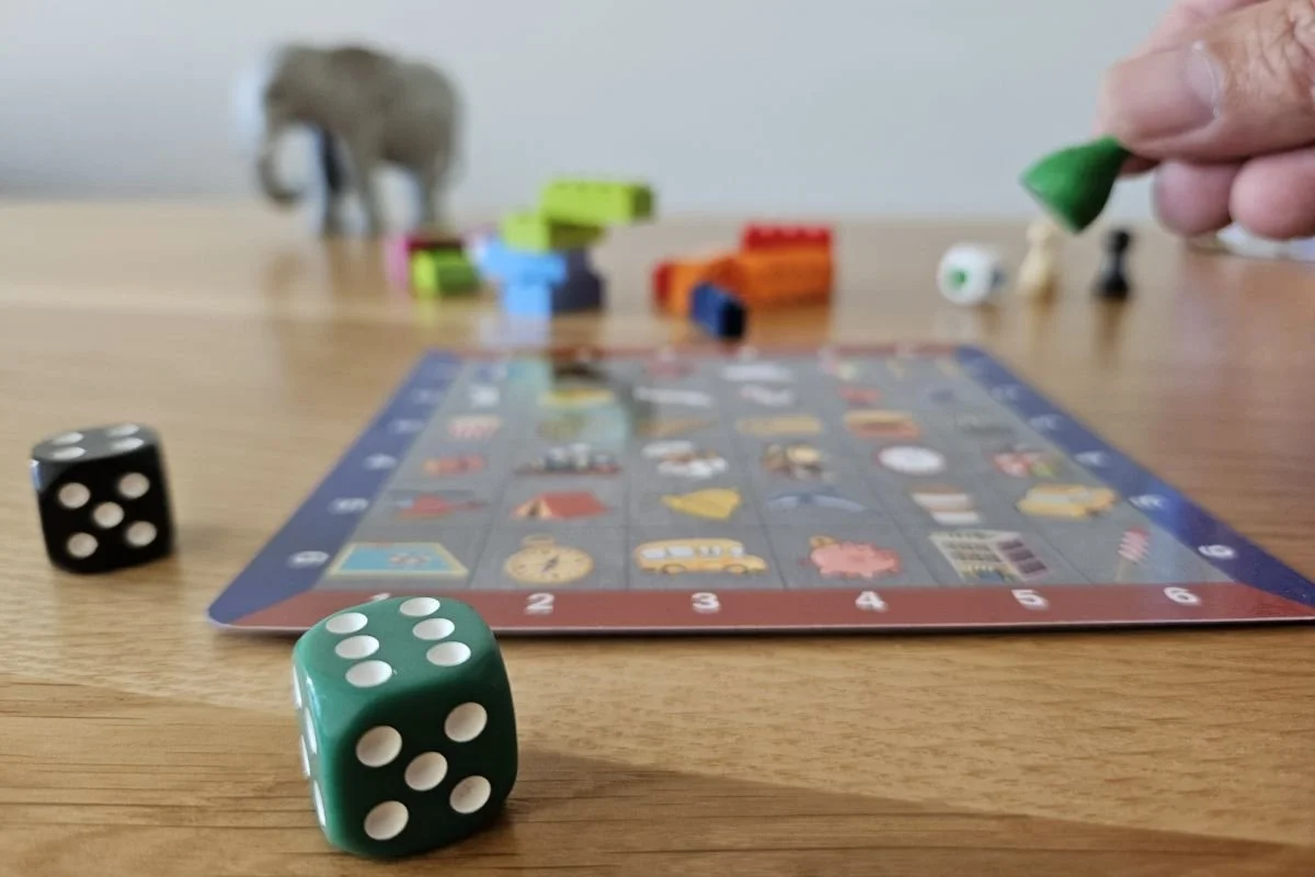 Spielbrett mit Symbolen, Würfeln und Spielfiguren, genutzt für die Brain2Business‑Methode.
