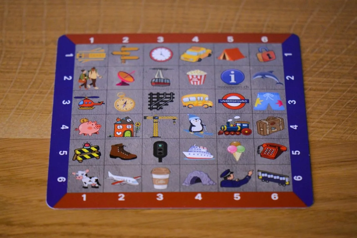 Vorderseite der Playmat Inspiration mit farbigem Symbolraster auf Holztisch.