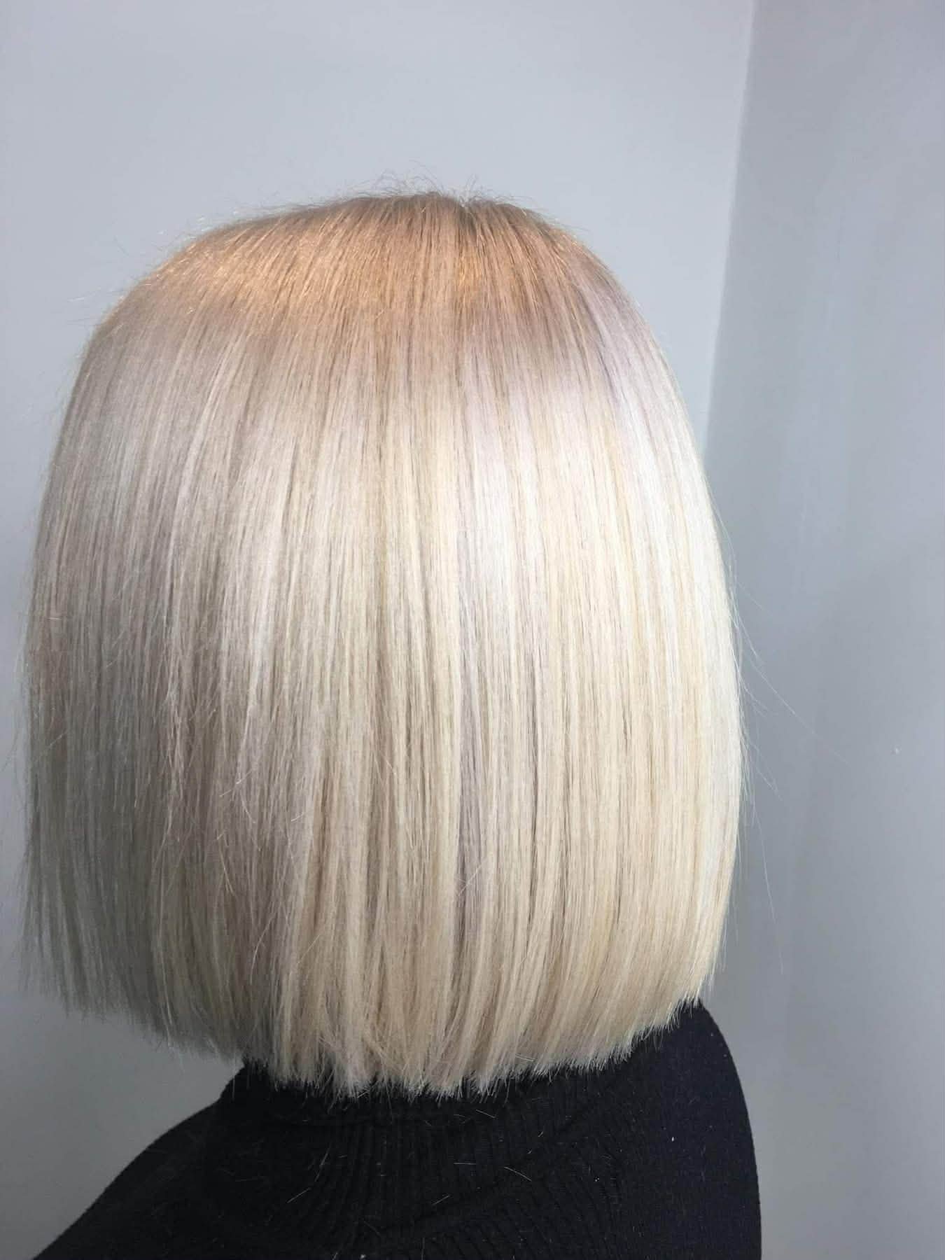 Back view of a person with a sleek, straight, platinum blonde bob haircut.