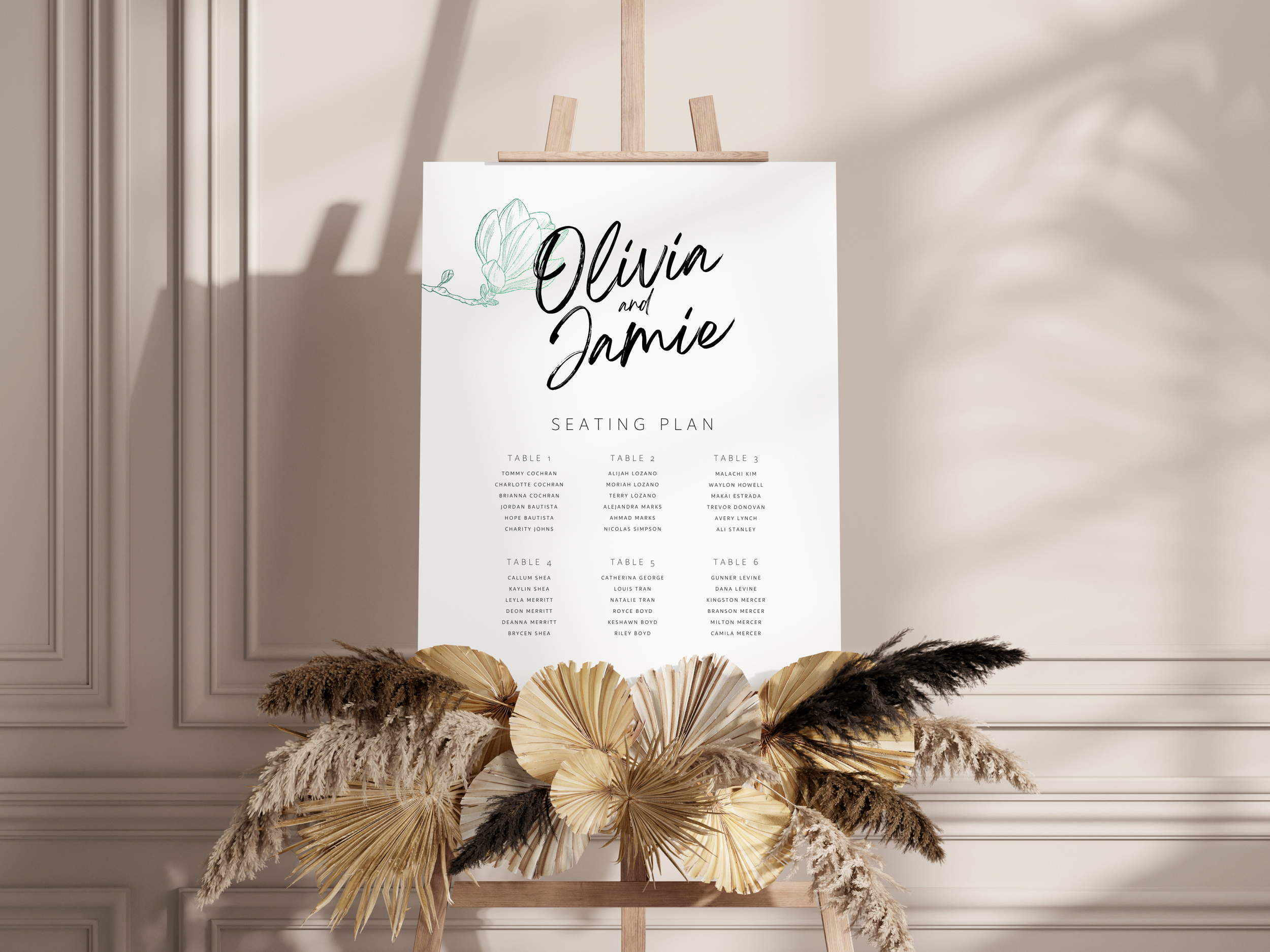 Wedding seating chart on an easel, surrounded by decorative dried plants and flowers at the base.