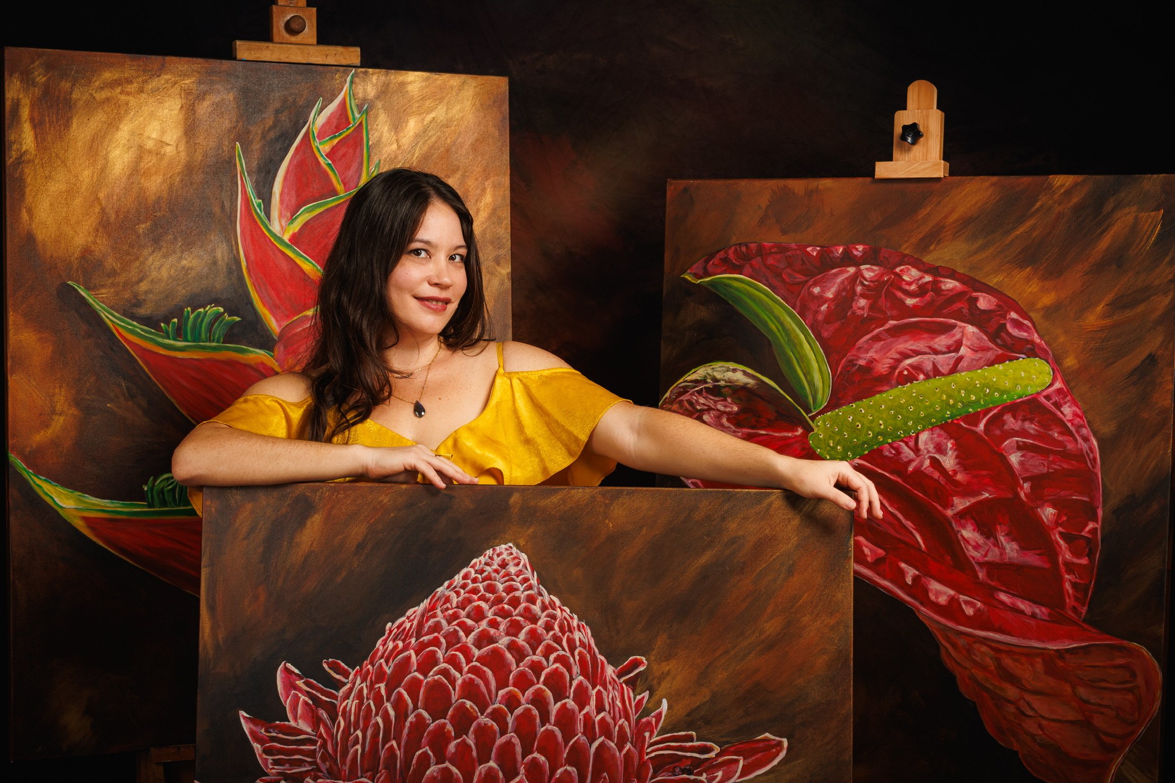 portrait of artist Elaine Yeh with three floral paintings