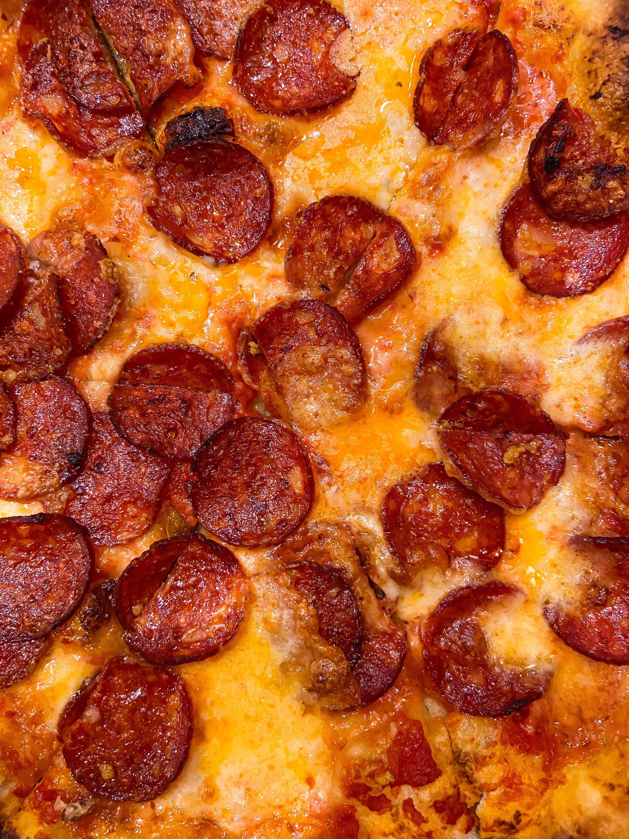 Close-up of a pepperoni pizza with melted cheese and crispy pepperoni slices.