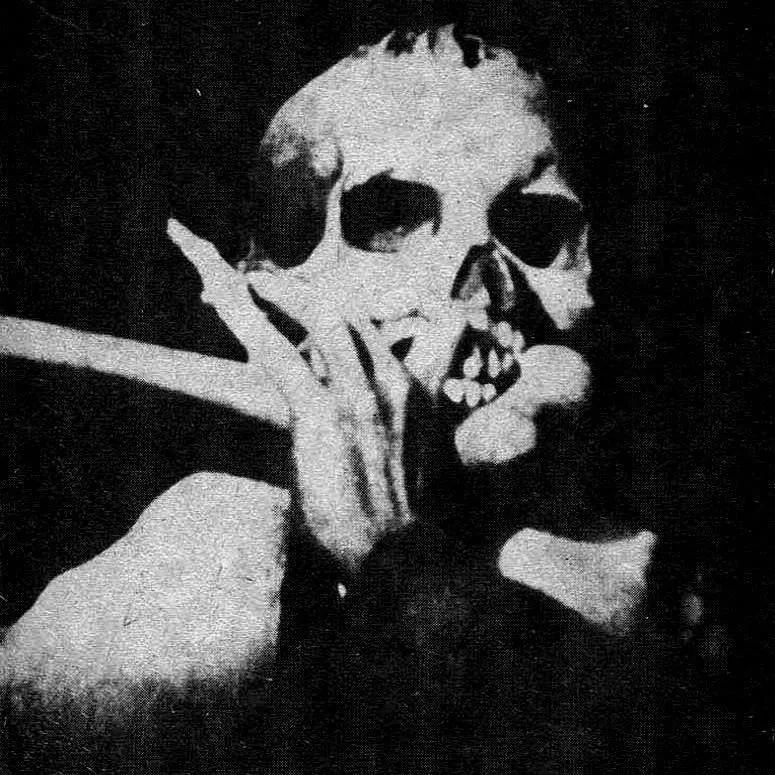 A black and white photo of a person with their face painted in a skeleton design, holding a cigarette near their lips.