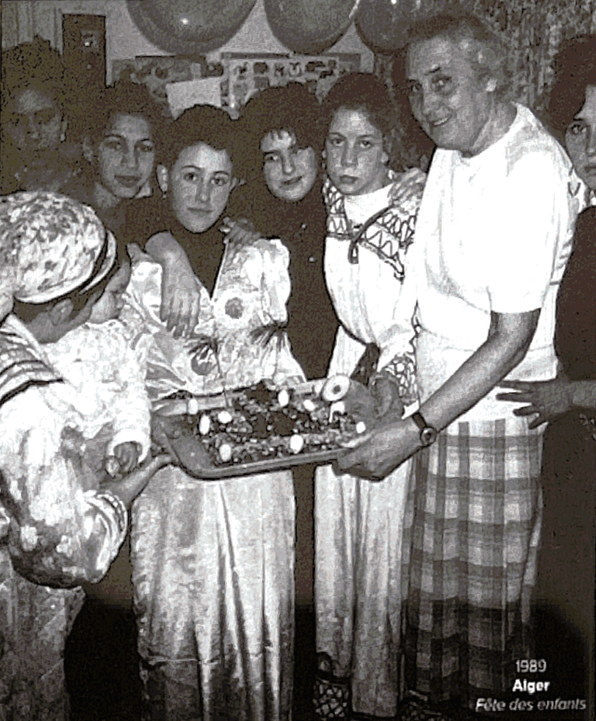 Groupe d'enfants et d'adultes lors d'une fête en 1989 à Alger, célébrant une occasion avec un gâteau.