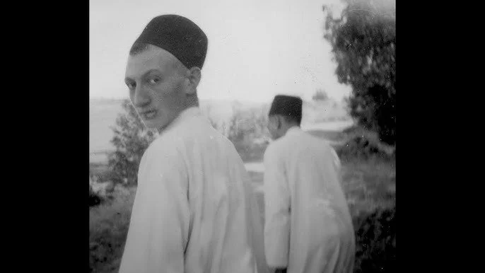 Deux hommes en boubou blanc et chapeaux traditionnels dans un paysage rural