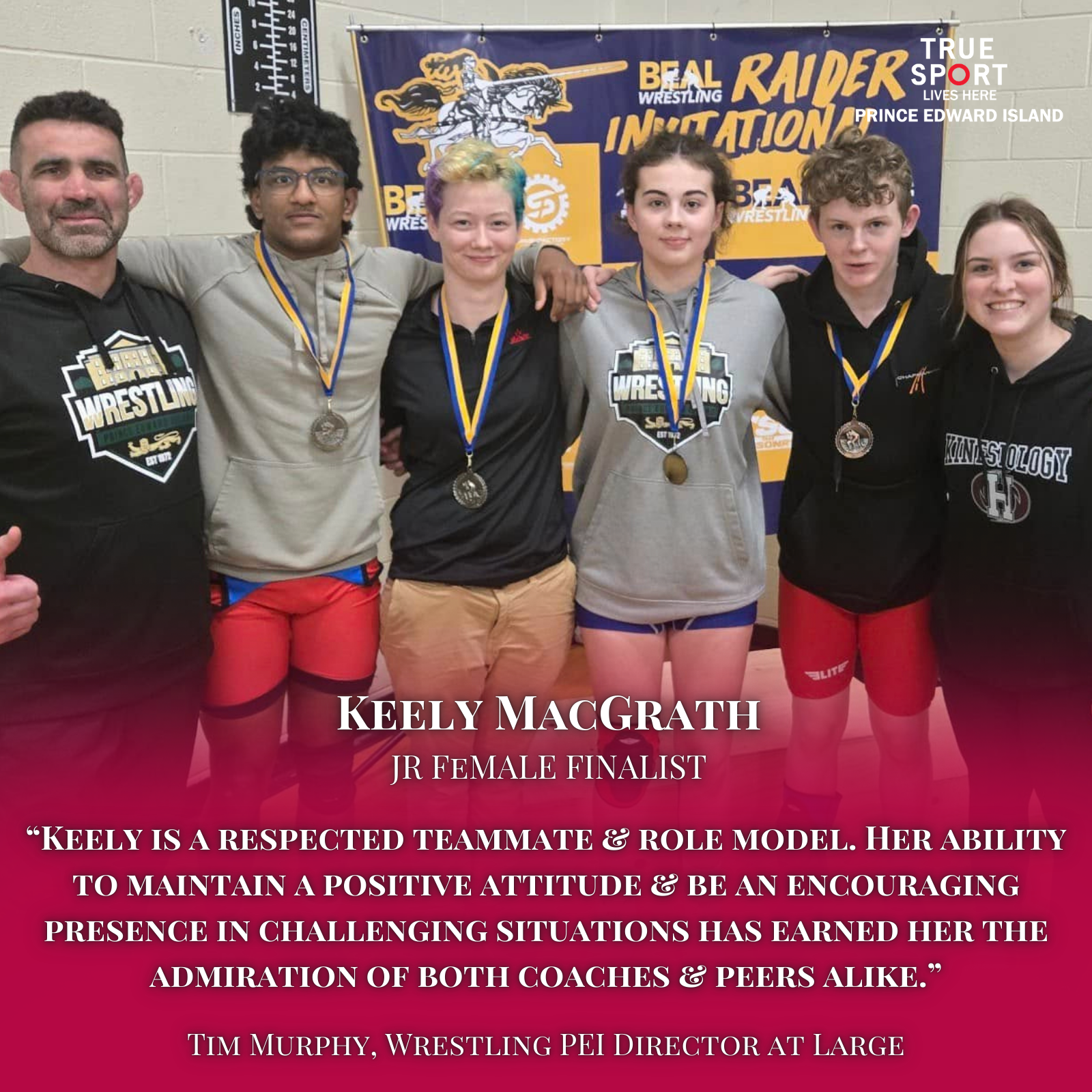 Group of six people, four female wrestlers and two coaches, standing together with medals, in front of a wrestling team banner after a competition. The banner has a tiger graphic and the words "BEAR RAIDERS INVITATION". The people are smiling and wea