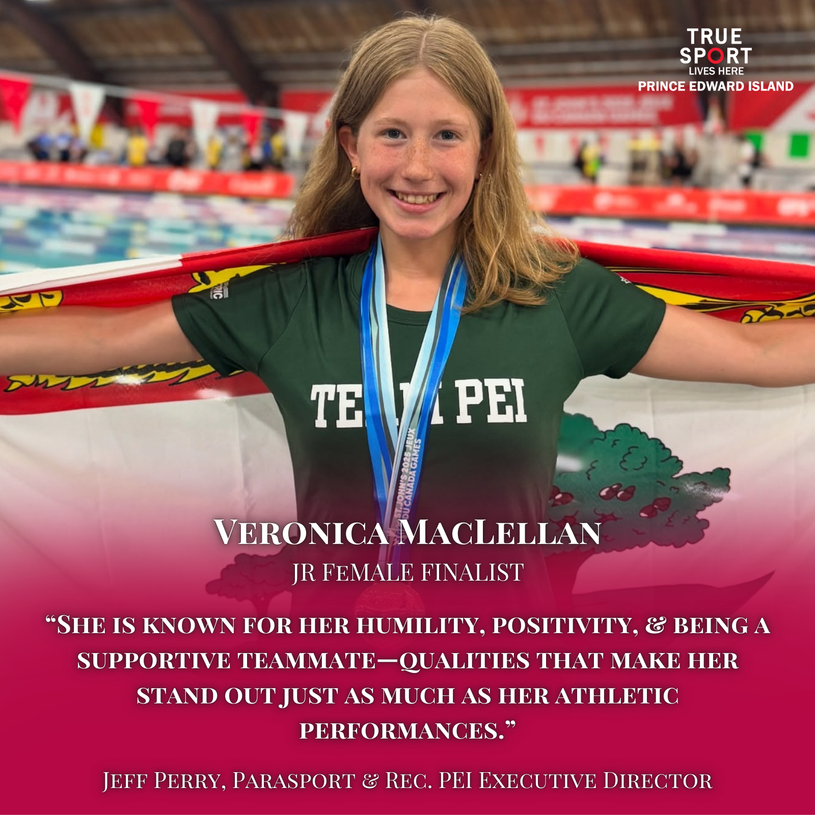 Young female athlete with red hair, wearing a green shirt that says "Taipei", holding an Olympic flag behind her shoulders, smiling, wearing medals around her neck, standing in an indoor swimming pool area with blurred spectators in the background.