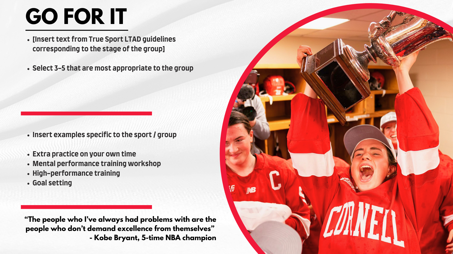 A group of young female hockey players in red jerseys celebrating in a locker room. One girl is holding a large trophy above her head, smiling with her mouth open. The background shows wooden shelves with hockey helmets and equipment.