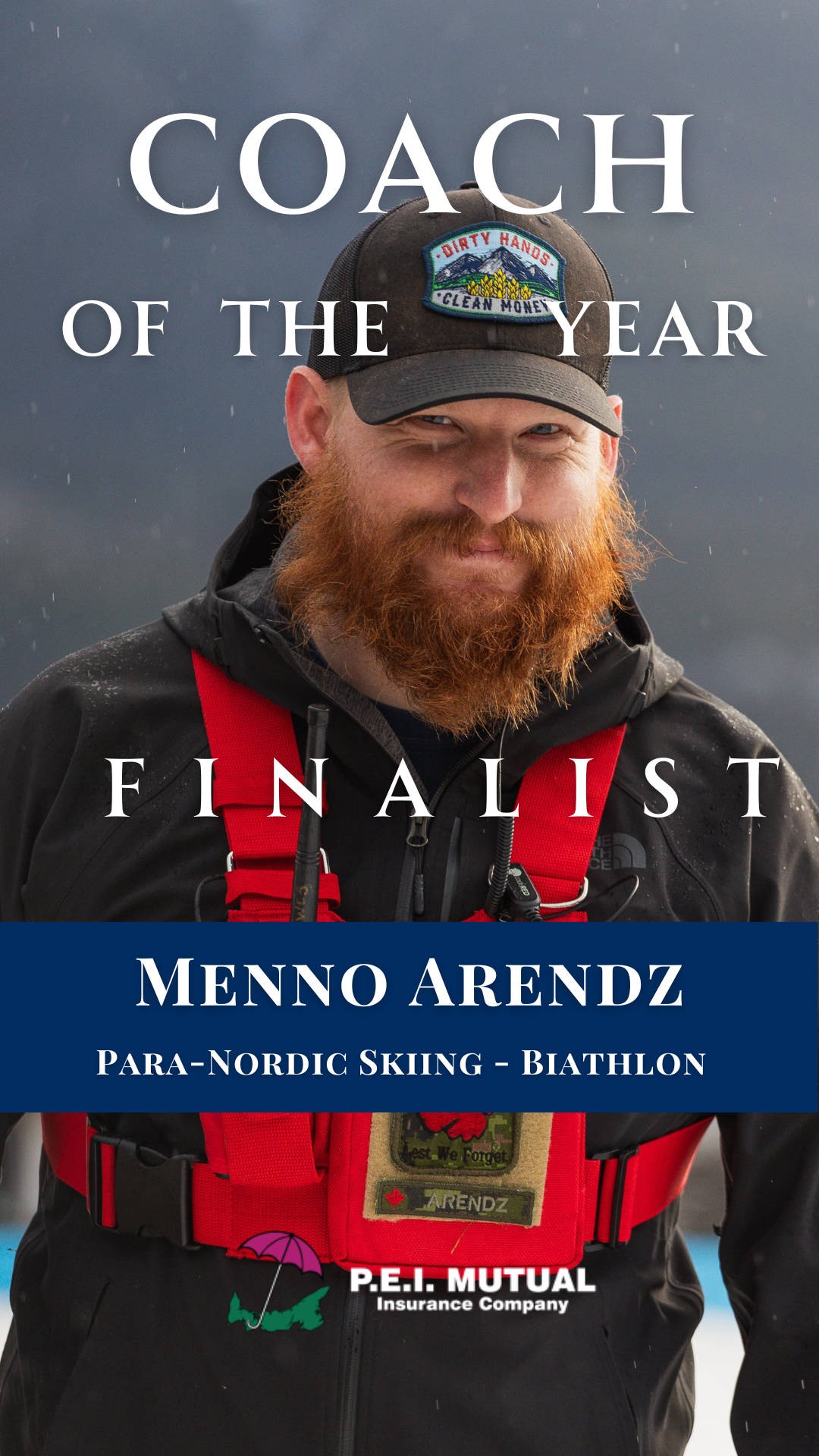A man with a red beard wearing a black cap with a patch that says "Dirty Hands, Clean Money" and a black jacket, smiling outdoors with rain and mountains in the background, promoting coach of the year award for Menno Arendz, a para-Nordic skier and b
