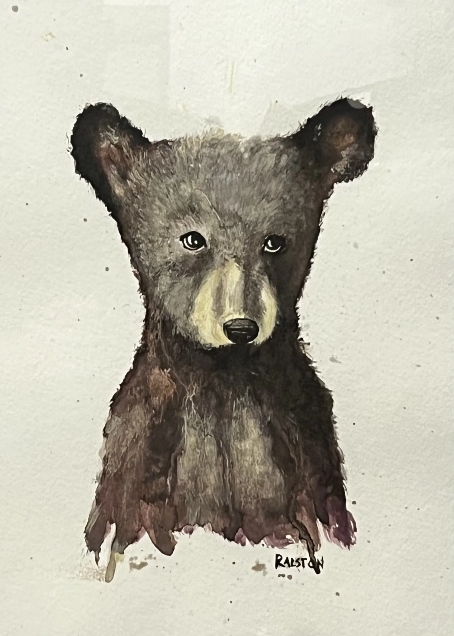 Watercolor painting of a bear cub with a focused expression, signature at the bottom right.