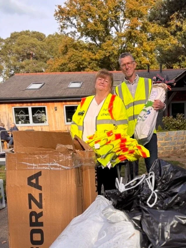 Pat and George Committee members in high vis jackets  counting up after a village litter pick