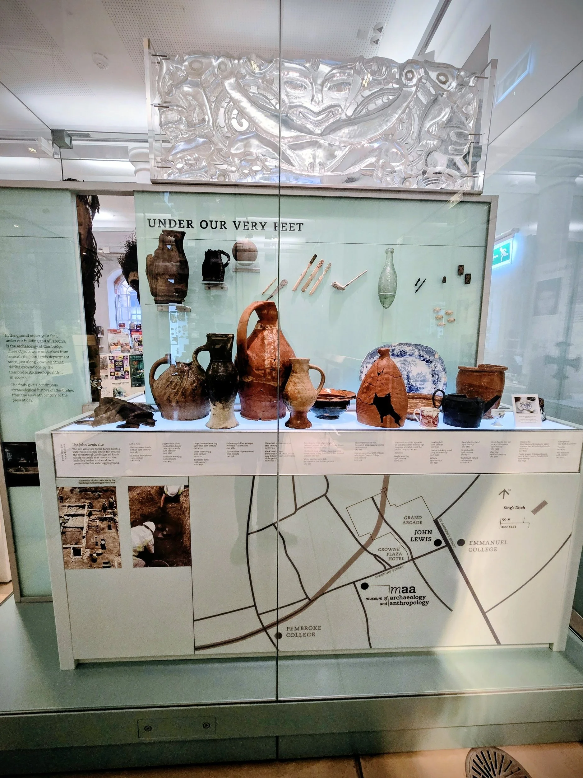 Display case showcasing ancient pottery and artifacts with a map and explanatory text, titled 'Under Our Very Feet'.
