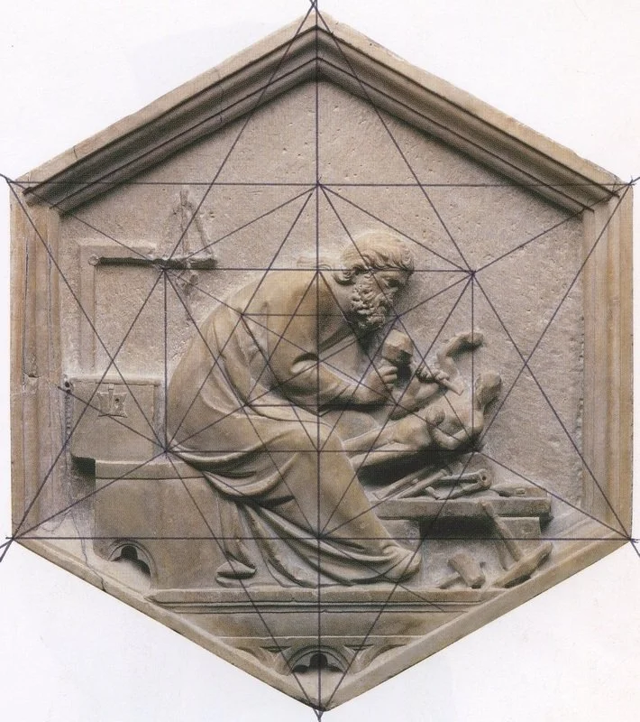 Stone relief sculpture of a man working at a desk, surrounded by tools, with a grid overlay