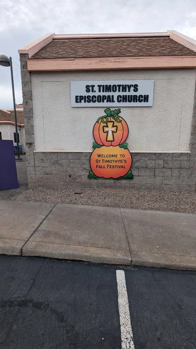 Sign for St. Timothy's Episcopal Church with a fall festival pumpkin decoration.