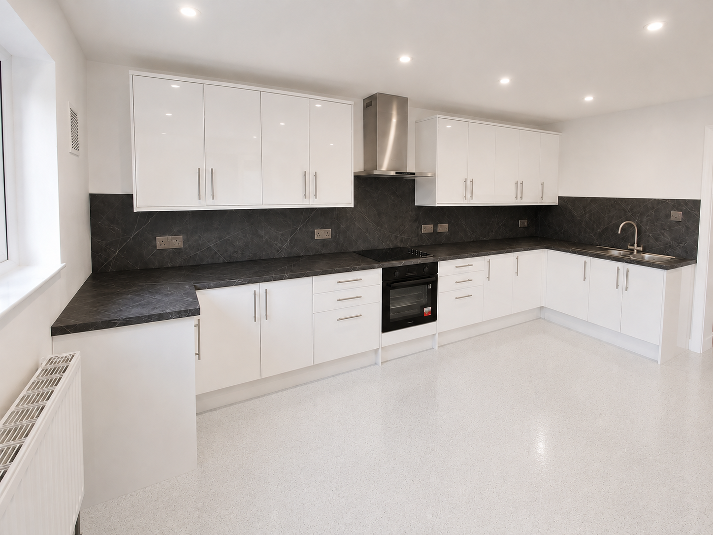Modern white gloss kitchen installation in Crowthorne with dark marble-effect worktops, matching splashbacks, stainless steel bar handles and tall storage, installed by Blacktail Kitchens.