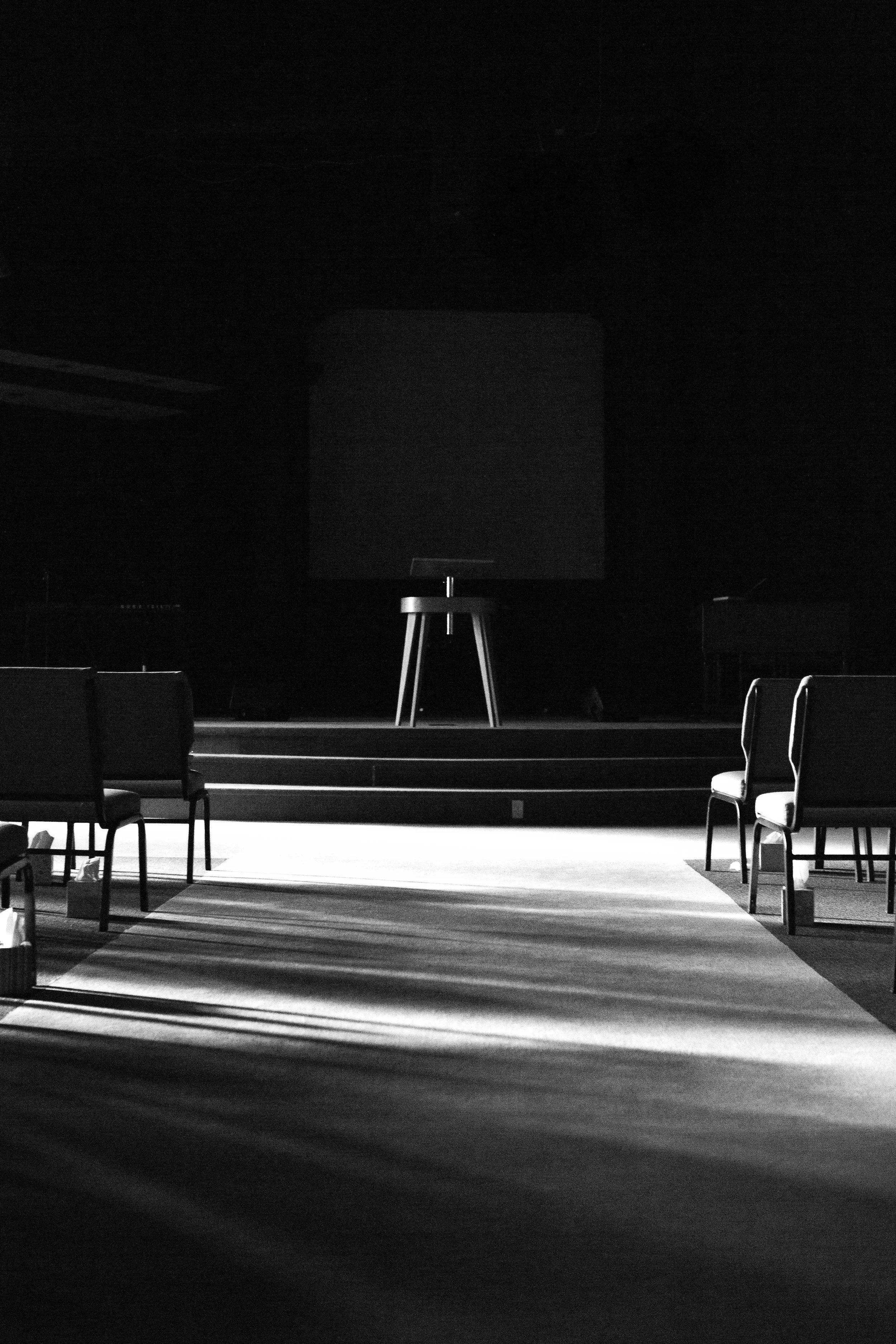 Stage with spotlight and chairs in a room, preparing for a presentation or performance.