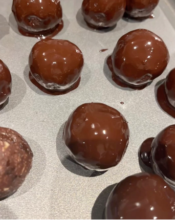 Close-up of several chocolate-covered balls on a baking sheet
