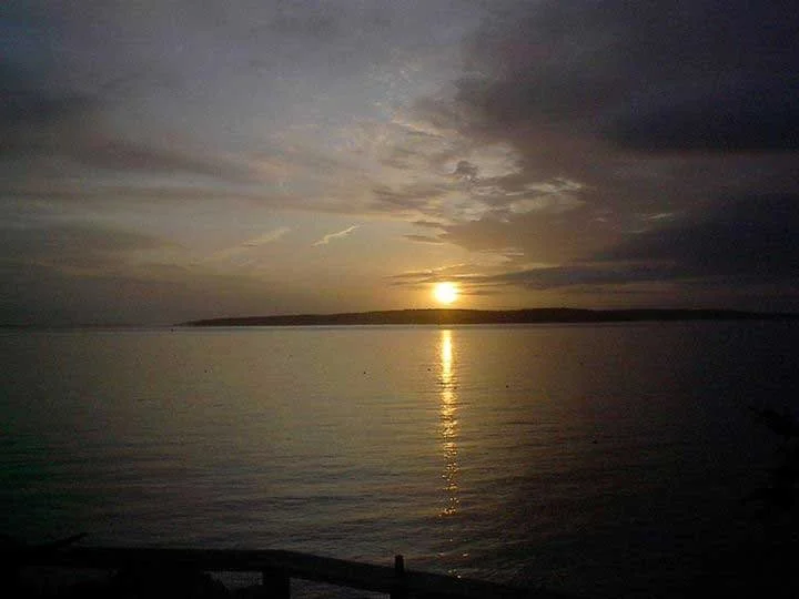 Sunrise on the lake with the sun reflecting in the water.