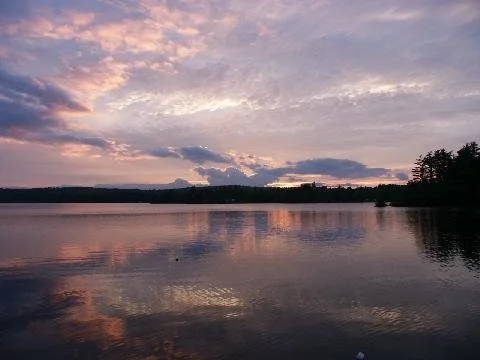 Sunset on the lake with sunset reflected in the water.