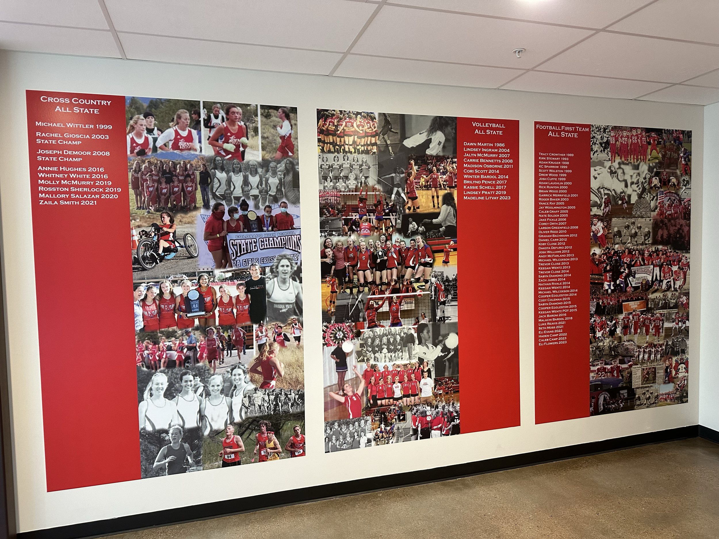 Wall display with photos of school sports teams and achievements, divided into sections for Cross Country, Volleyball, and Football, with lists of players and accomplishments.