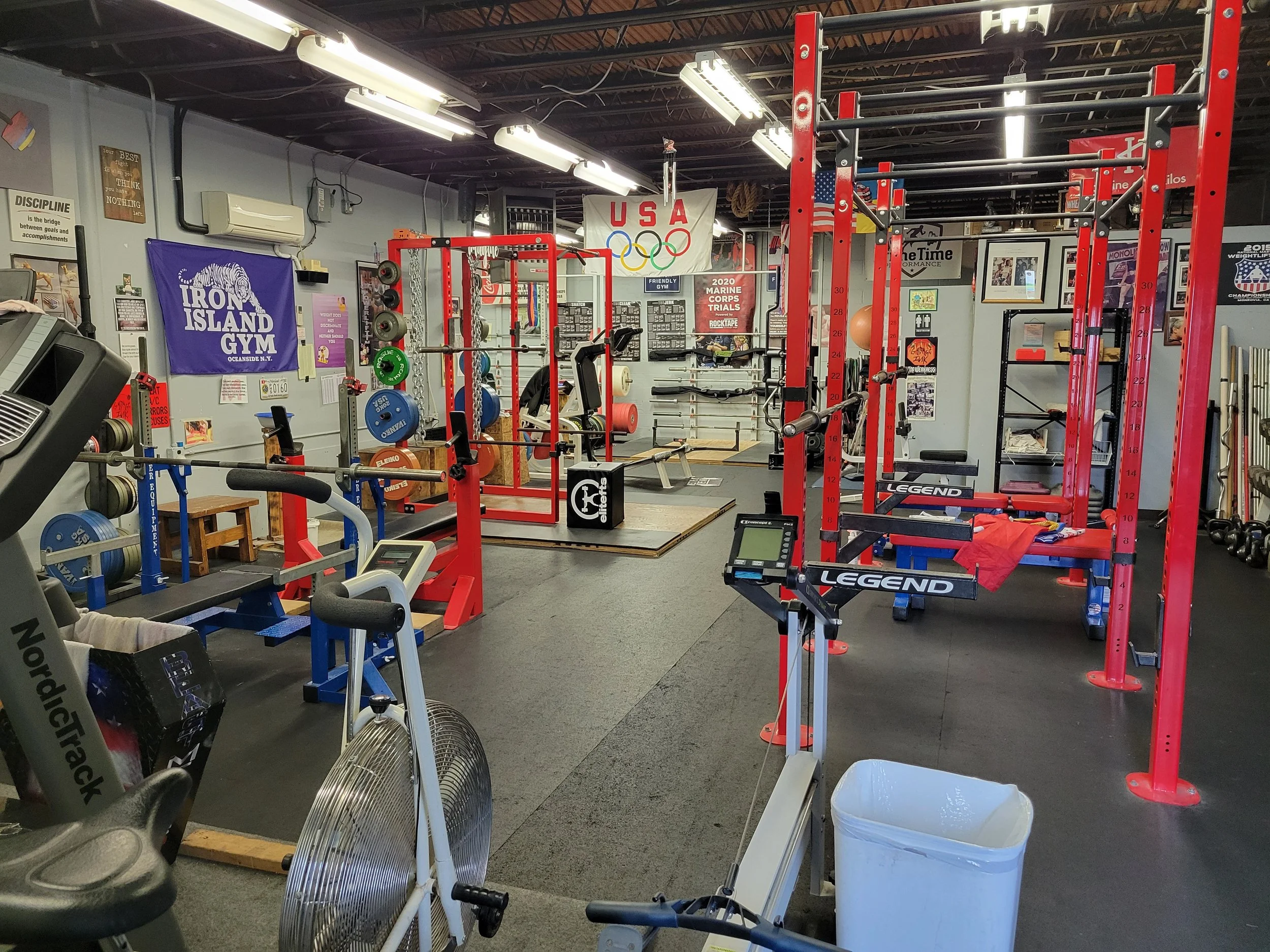 Weightlifting platforms, squat racks, and dumbbells inside OTB Strength training facility in Rockville.