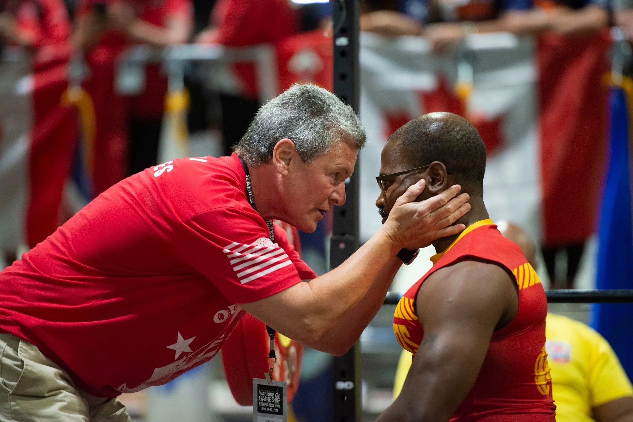 Coach LJ speaking closely with an adaptive athlete during the Warrior Games.