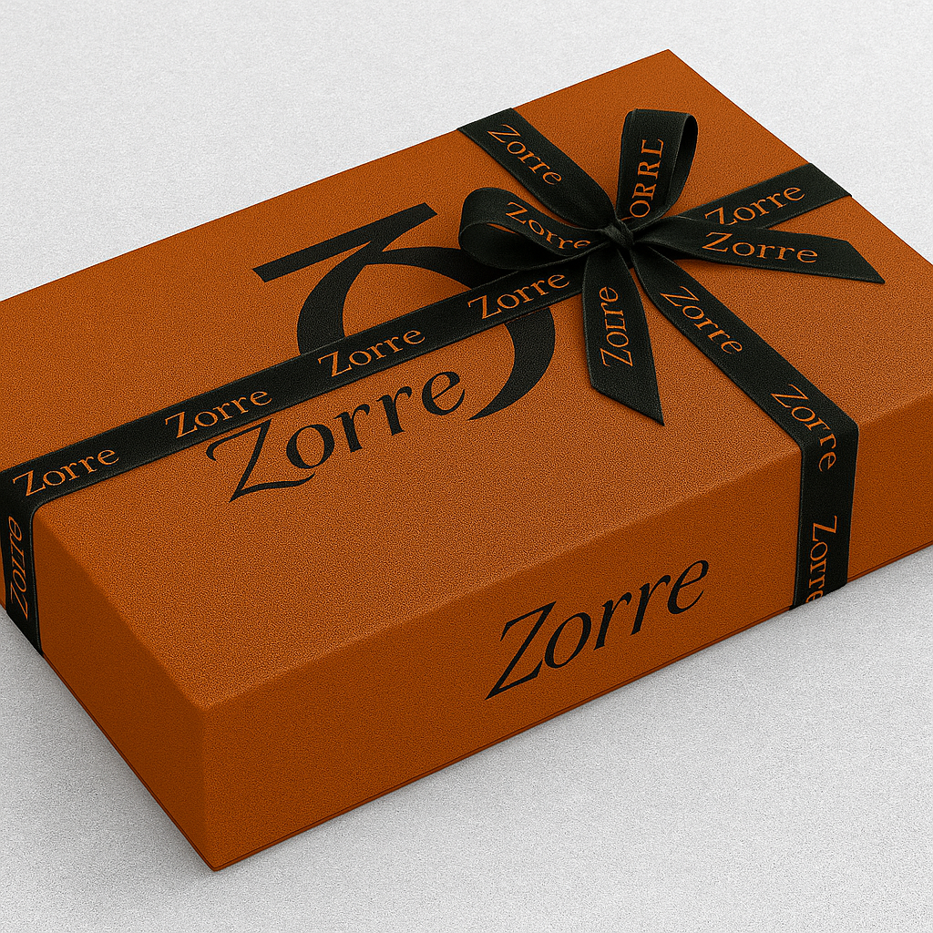 A rectangular orange gift box wrapped with a black ribbon that has the brand name "Zorre" printed on it. The ribbon is tied in a bow on top of the box, which also features the "Zorre" logo and name printed on the surface.