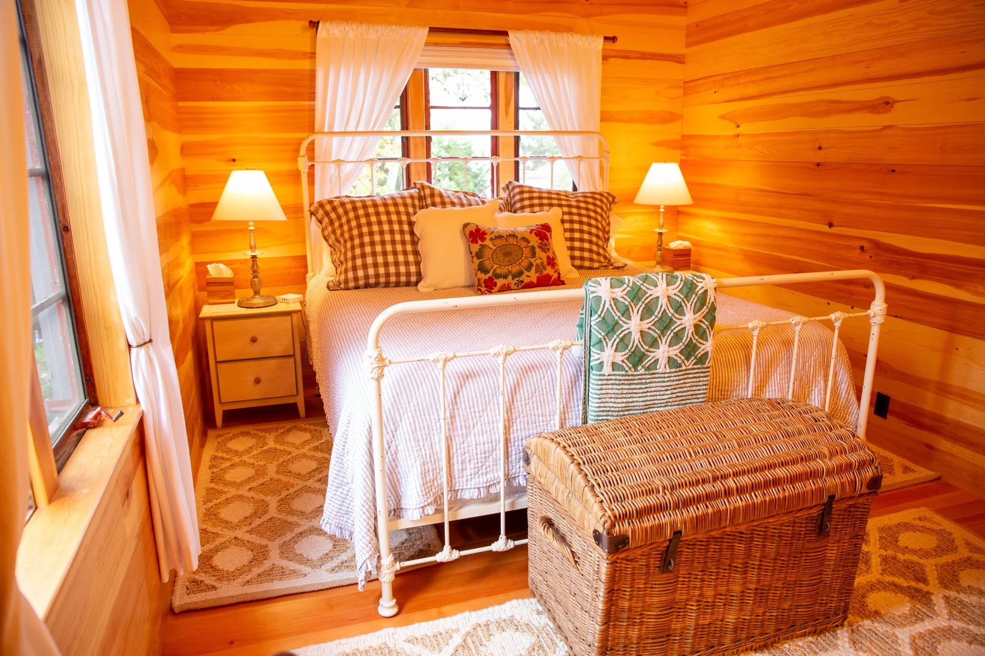 high-head-brooklin-maine-bedroom-white-iron-bed-floral-pillows-windows.jpg
