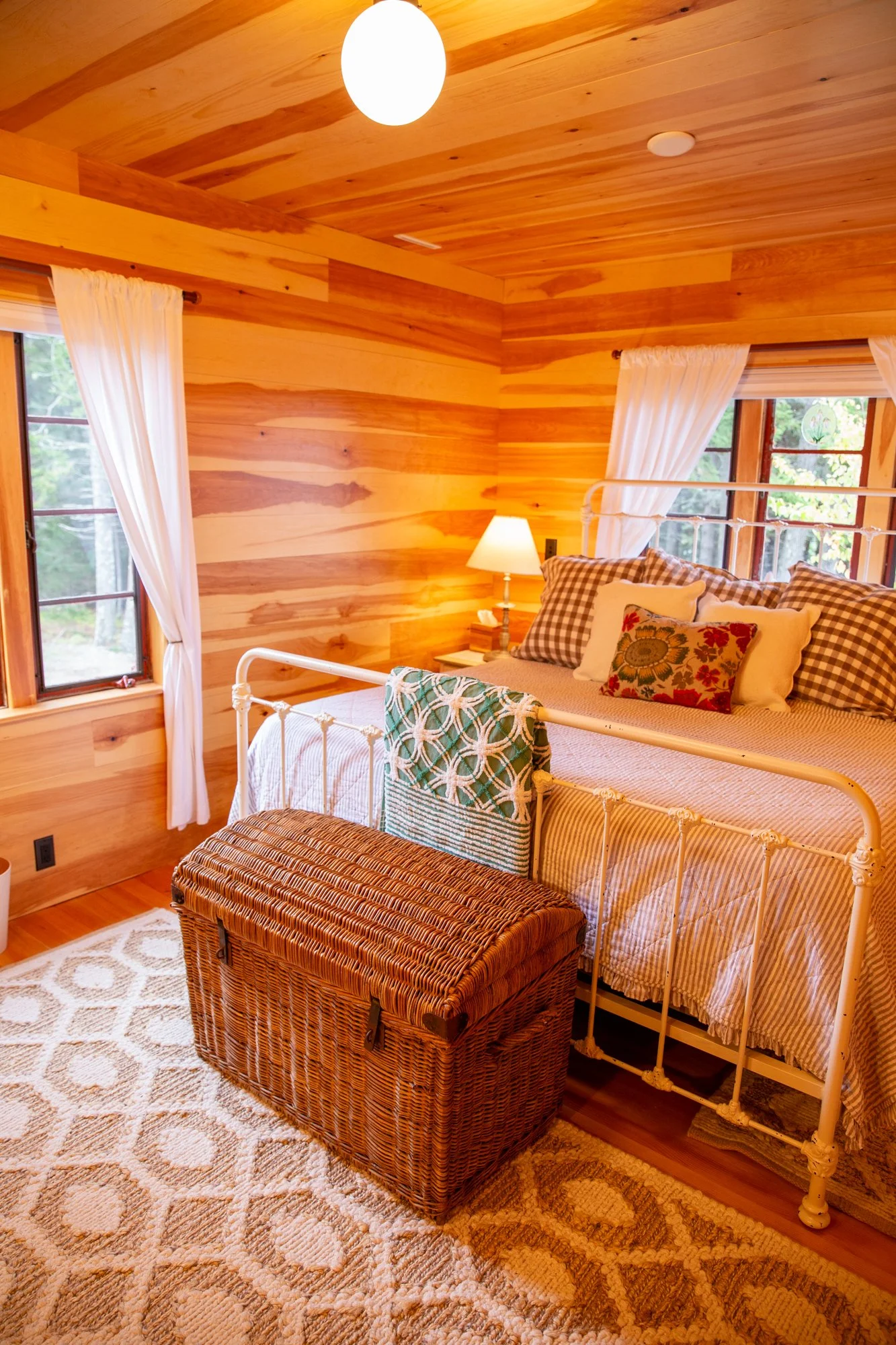 high-head-brooklin-maine-bedroom-white-iron-bed-rattan-trunk-plaid-pillows.jpg