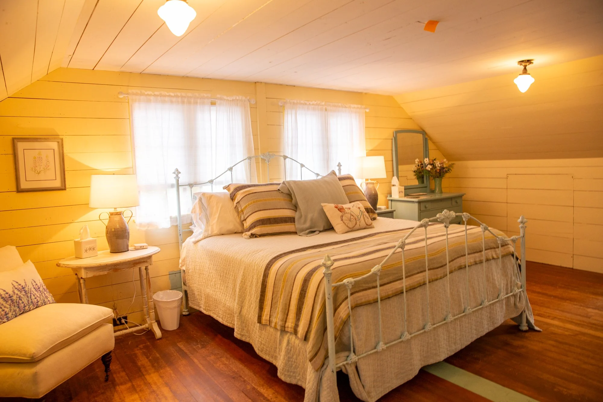 high-head-brooklin-maine-loft-master-bedroom-yellow-walls-white-iron-bed.jpg