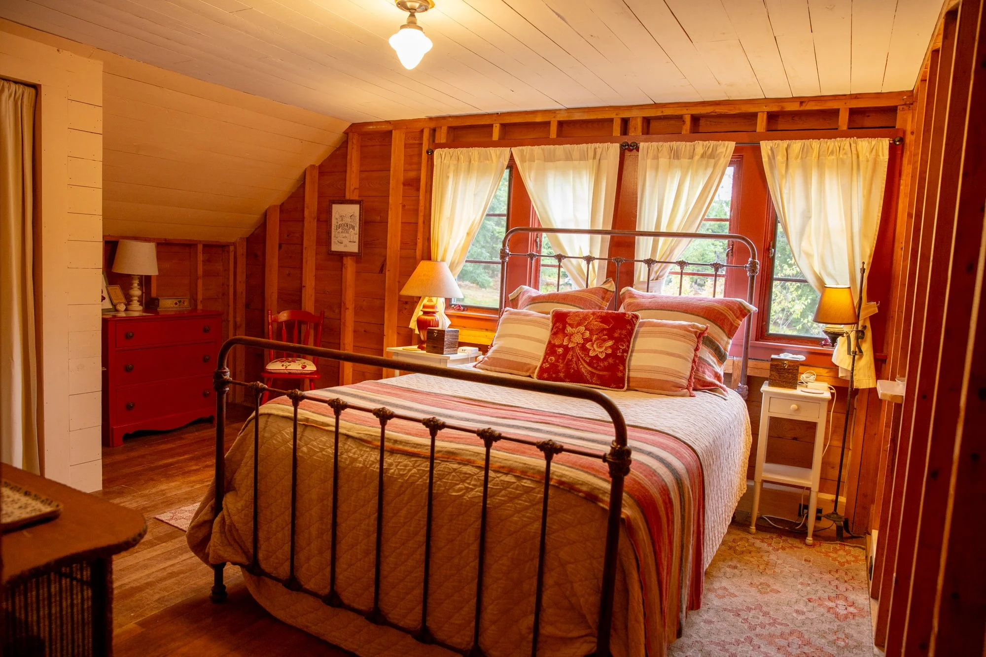 high-head-brooklin-maine-master-bedroom-iron-bed-sloped-ceiling-red-dresser.jpg