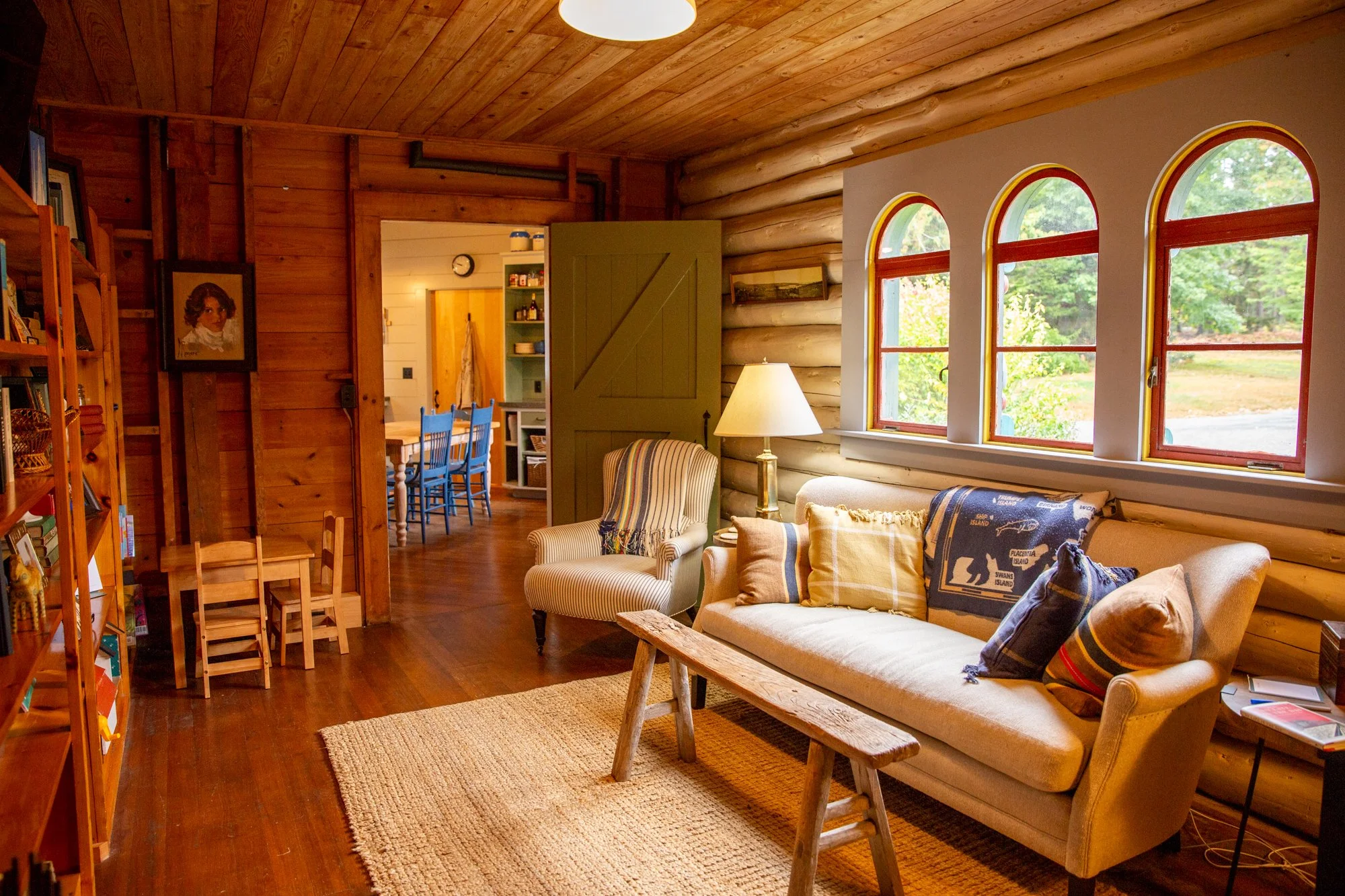 high-head-brooklin-maine-sitting-room-log-walls-arched-windows-bookshelves.jpg