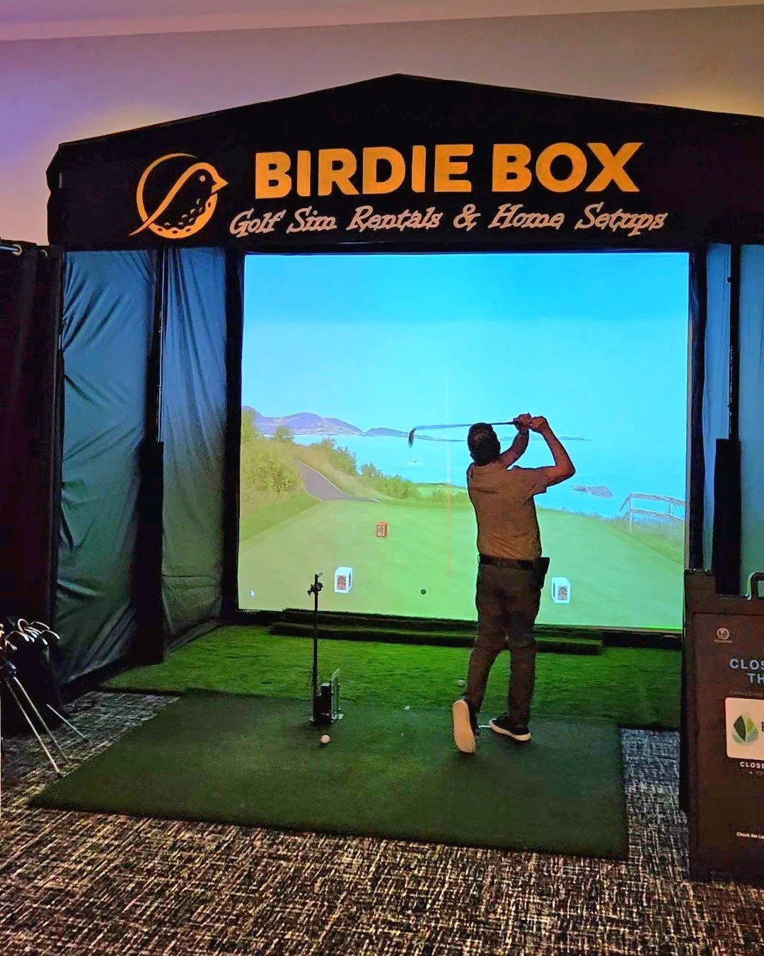 Man playing golf in Birdie Box golf simulator