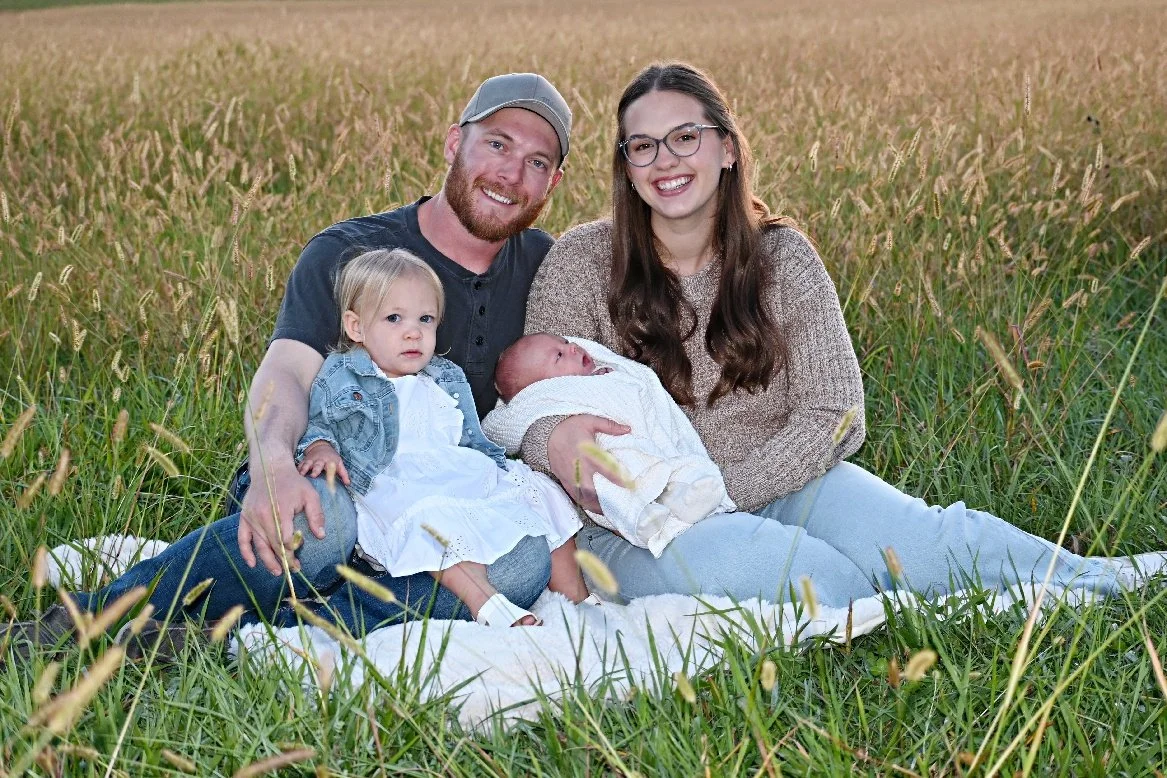 Owner of Brookfield, MO excavation company sits in field with his family.