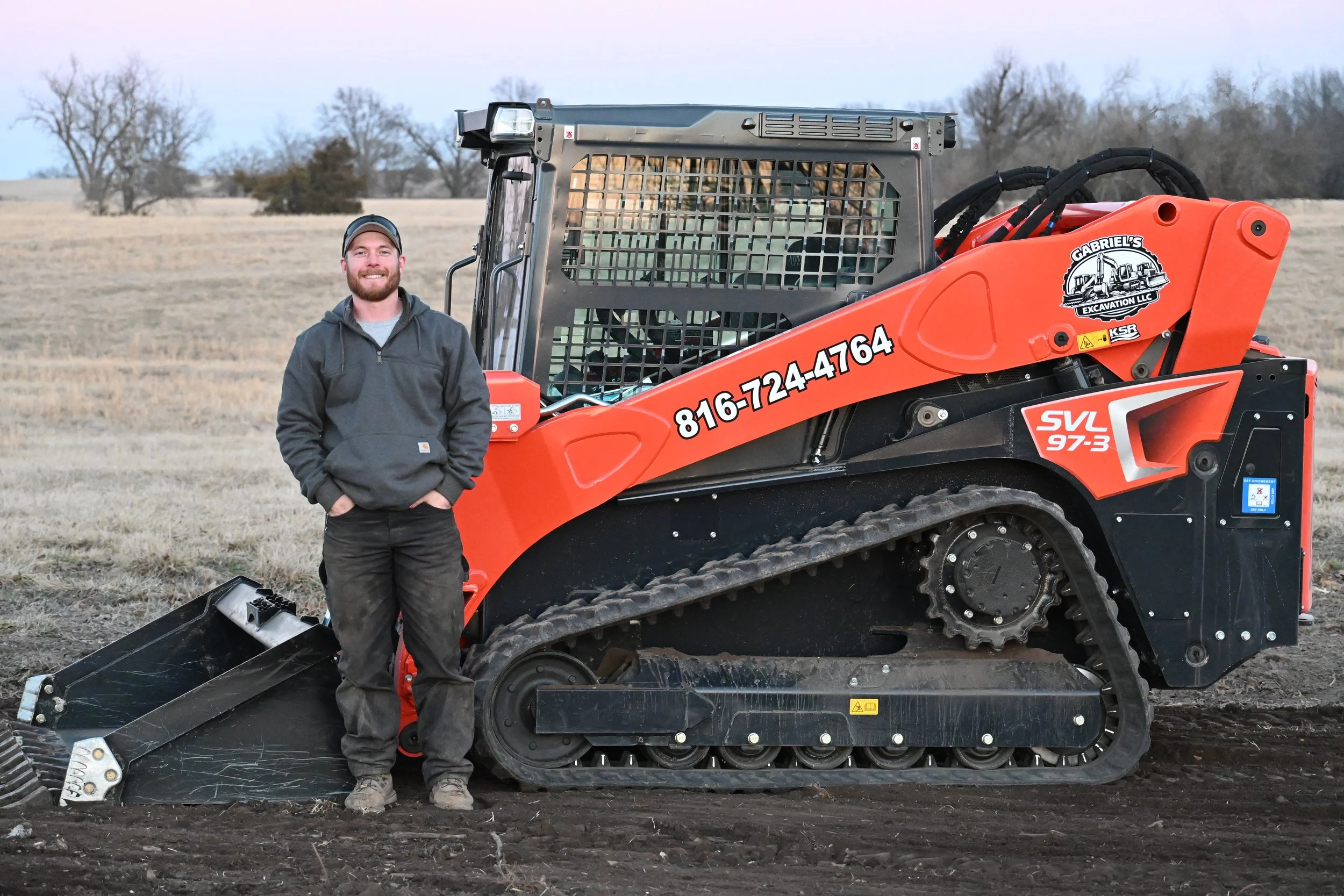 Kayne Lamison of Gabriel's Excavation stands by skid steer on project site in Cameron, Missouri.