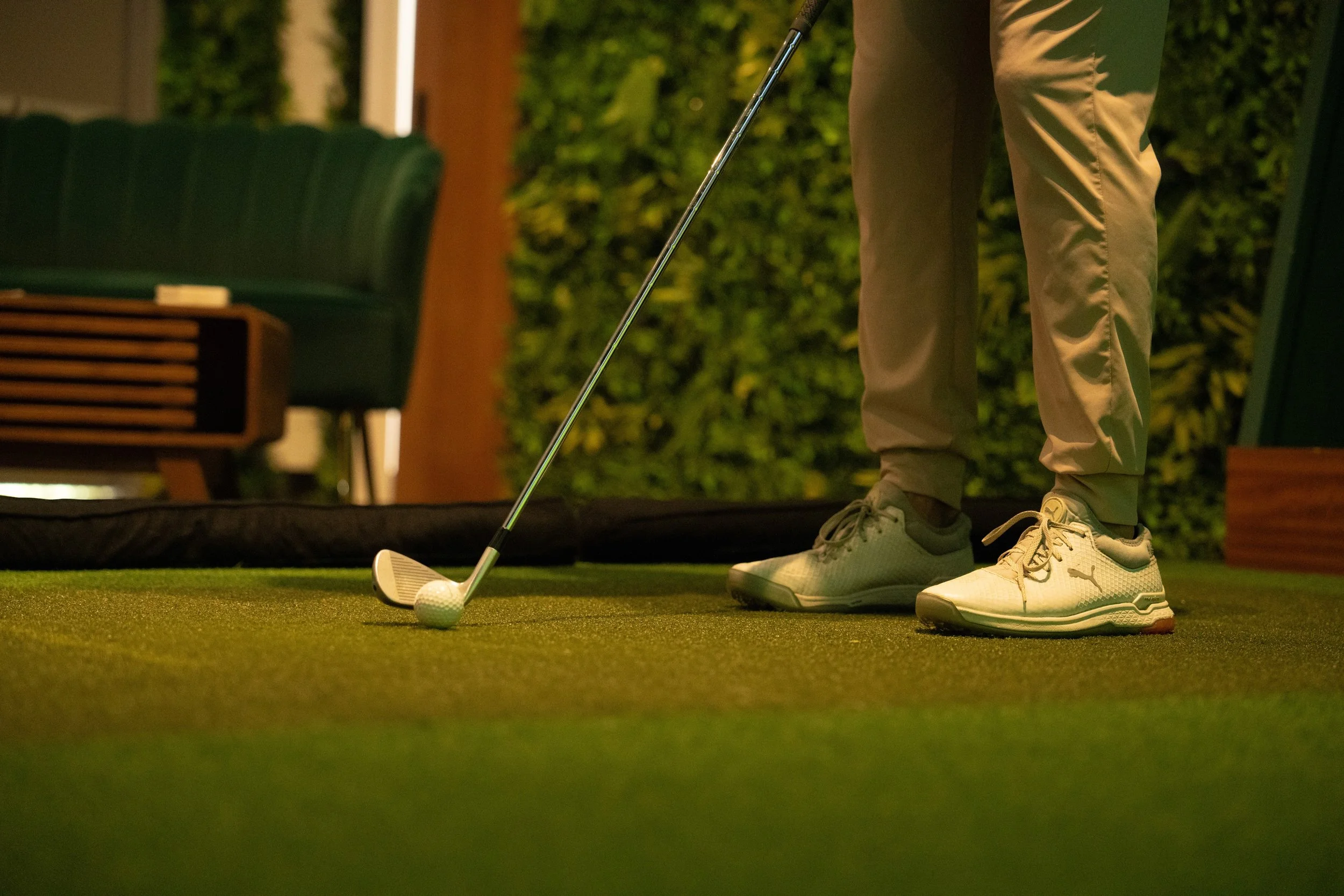 Golfer practicing on indoor putting turf at Beachside Greens golf simulator studio in Pacific Beach San Diego