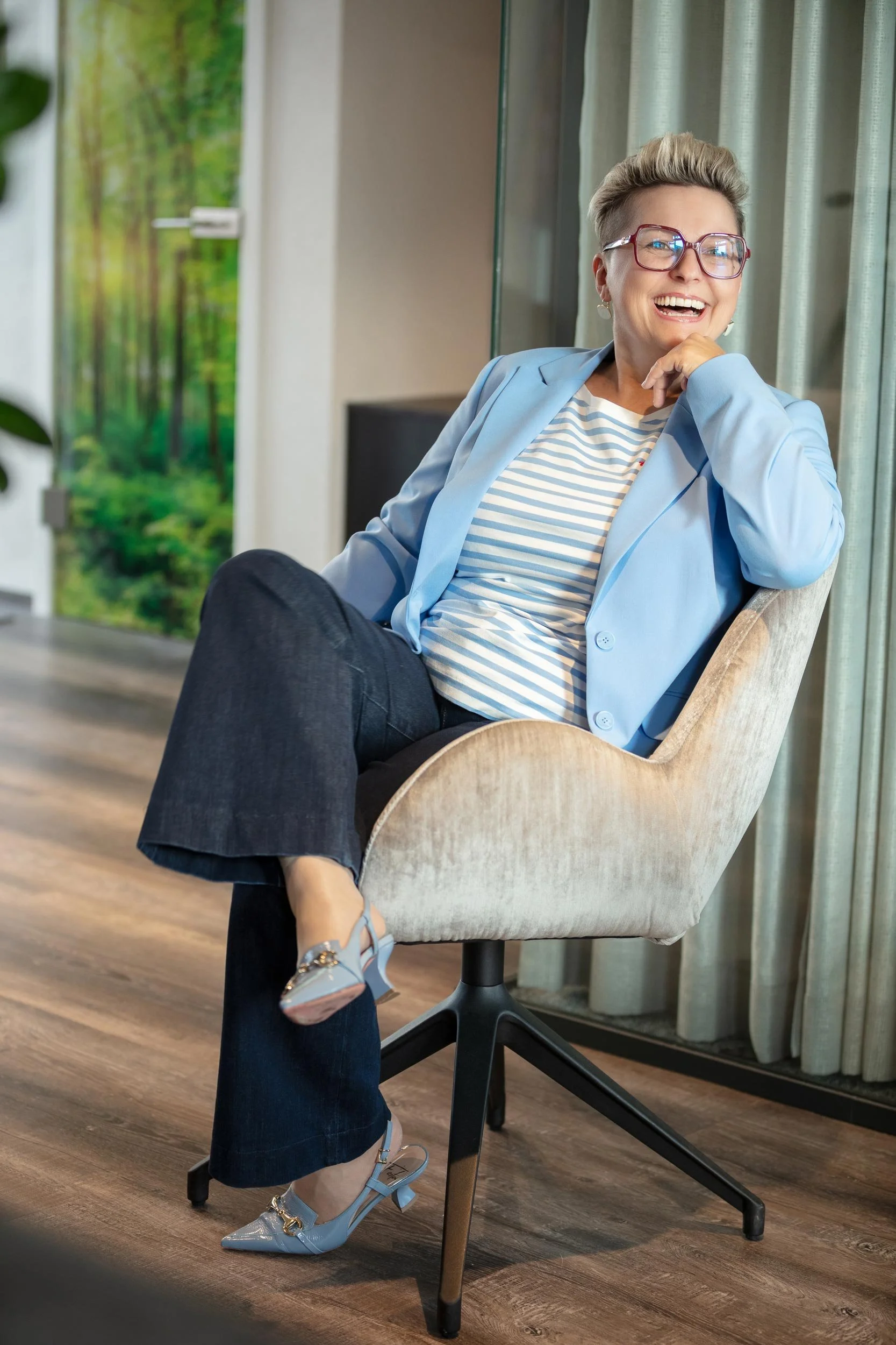 Regina Lackner Bilanzbuchhalterin sitz auf einem Stuhl und lacht