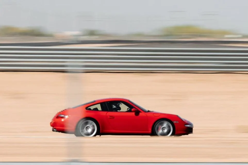 Red Porsche 911 accelerating on a performance driving course near Scottsdale, Arizona.