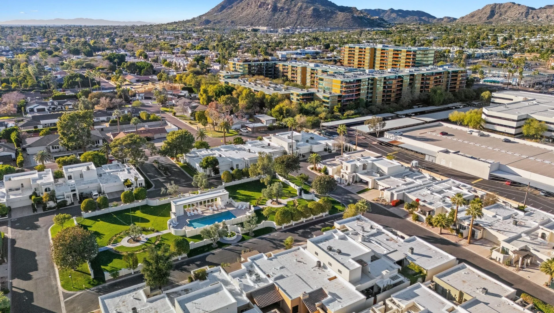 Aerial view of a Scottsdale luxury townhome community with landscaped grounds, community swimming pool and Camelback Mountain in the background.