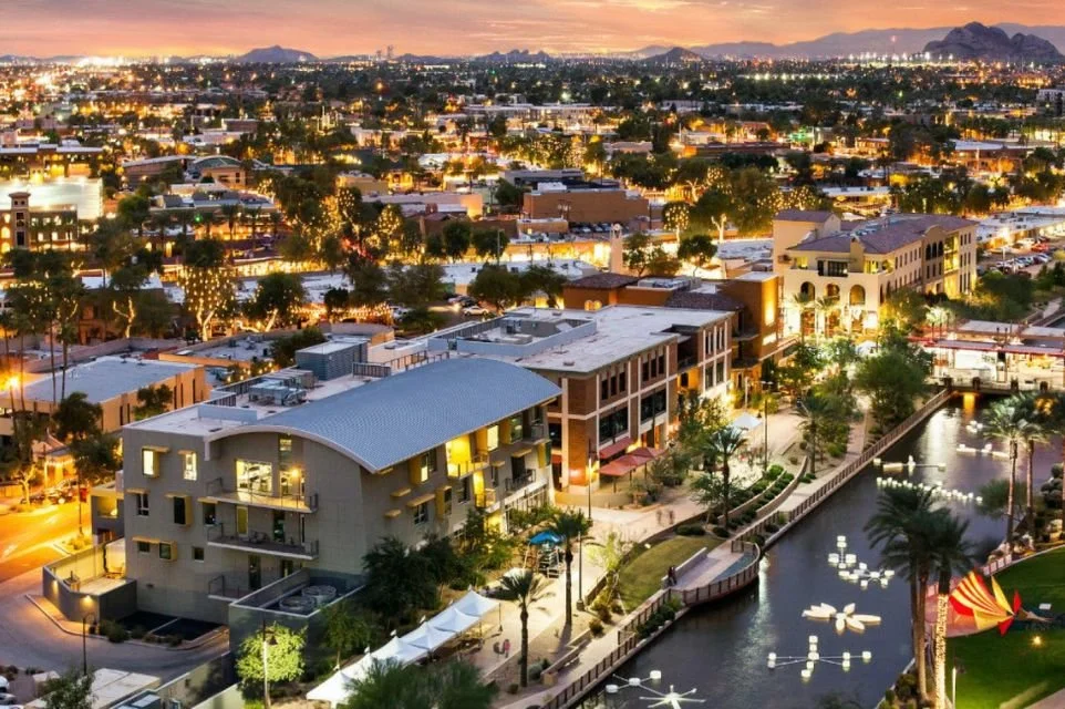 Scottsdale Waterfront at sunset featuring luxury residences, Scottsdale Canal, restaurants, and city lights in Old Town Scottsdale.