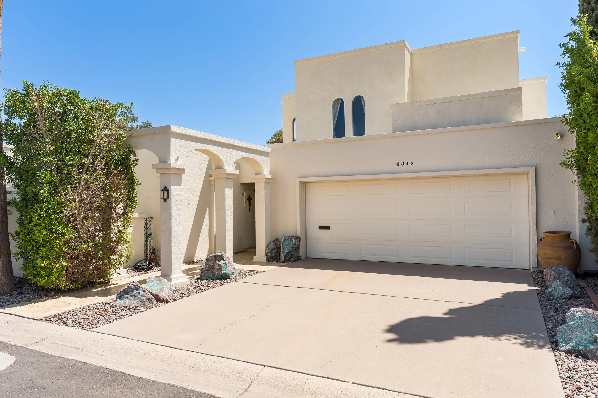 Front exterior of 4317 N 70th Street in Villa Adrian, a two-story Santa Fe style home with arched entry and two-car garage