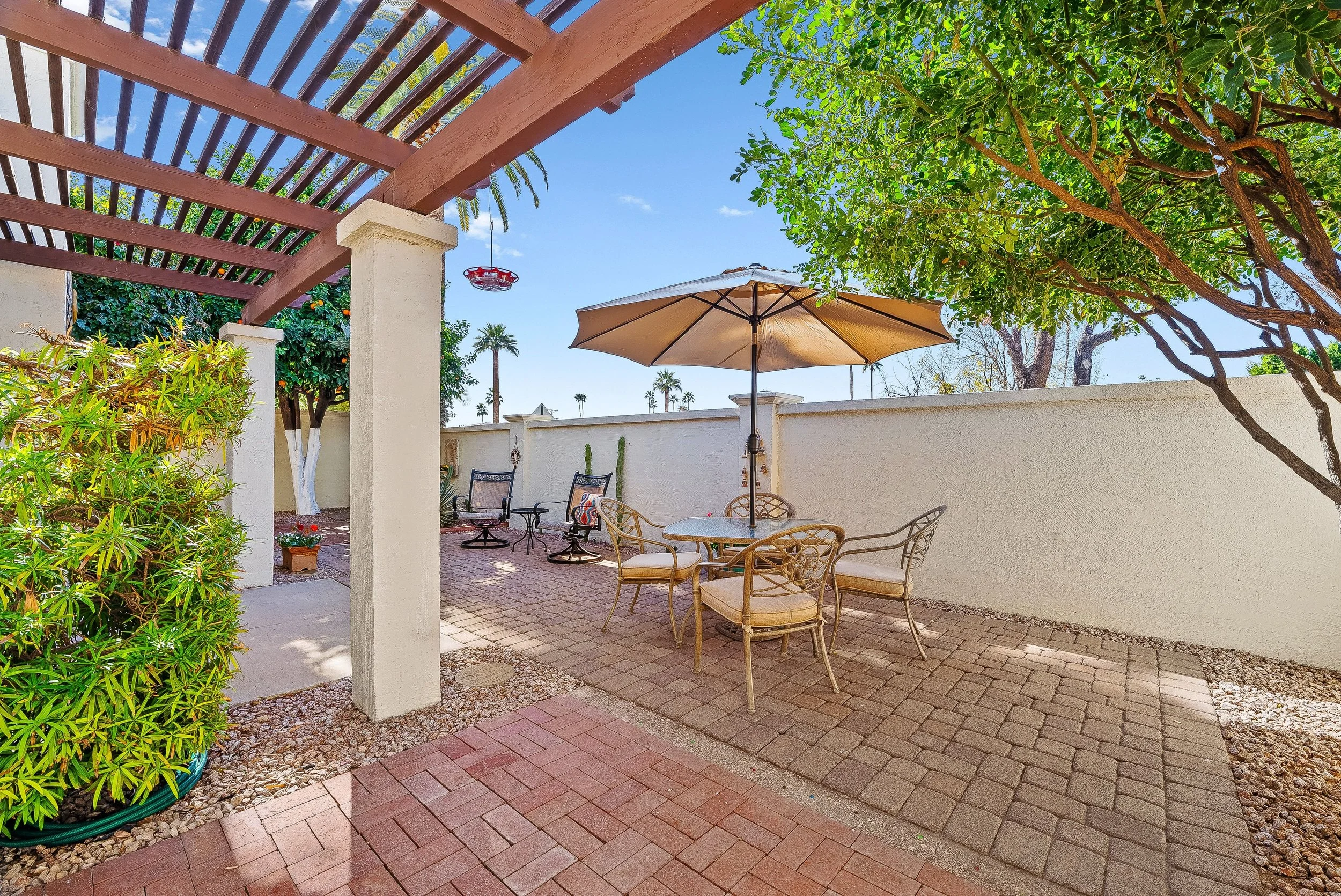 Private courtyard patio with pergola shade structure outdoor dining and paver flooring in Villa Adrian Scottsdale Arizona