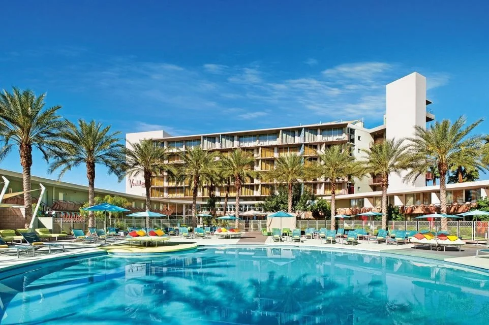 Main resort pool at Hotel Valley Ho in Old Town Scottsdale featuring palm trees, colorful lounge chairs, and iconic mid-century modern architecture.