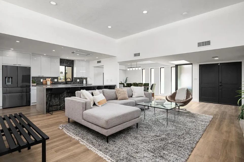 Open-concept Phoenix living room with modern kitchen, large sectional sofa, hardwood floors, recessed lighting, and contemporary finishes in a bright, spacious layout