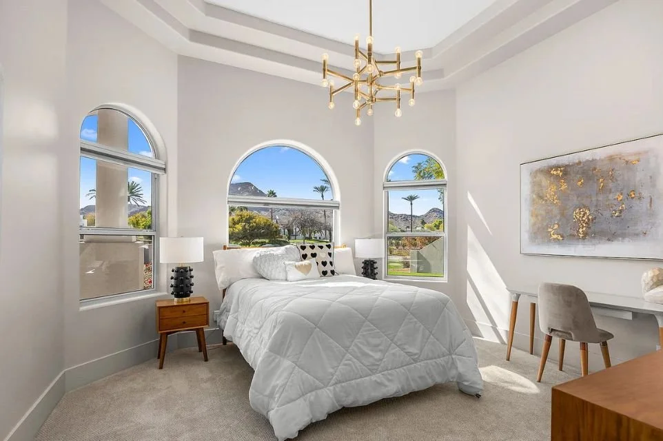Bedroom with arched windows and mountain views in a Paradise Valley, Arizona luxury home