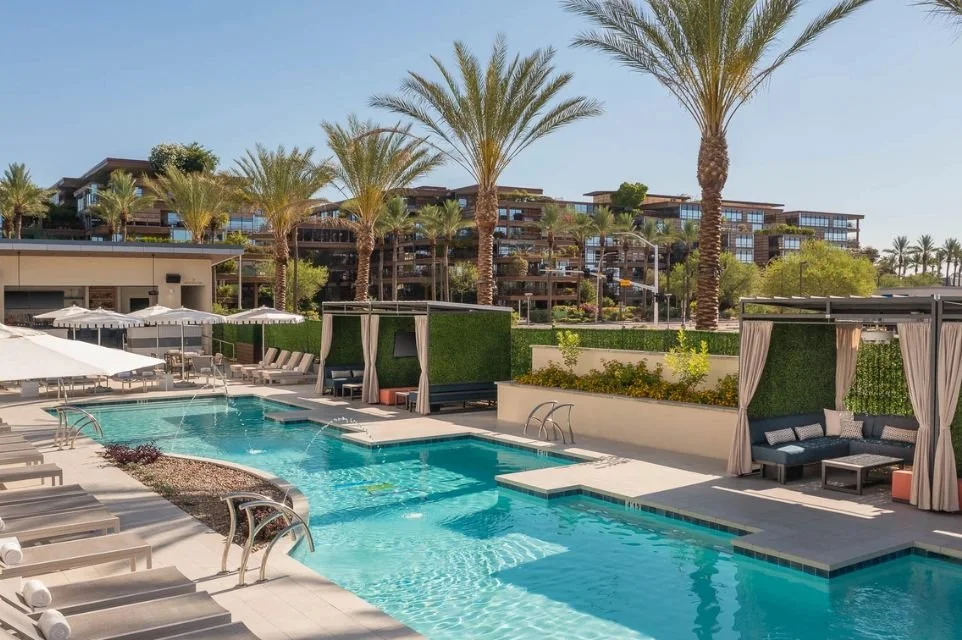 Resort-style pool at Caesars Republic Scottsdale with private cabanas, palm trees, and luxury accommodations near Old Town Scottsdale.